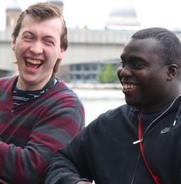 Two men sat outside laughing together