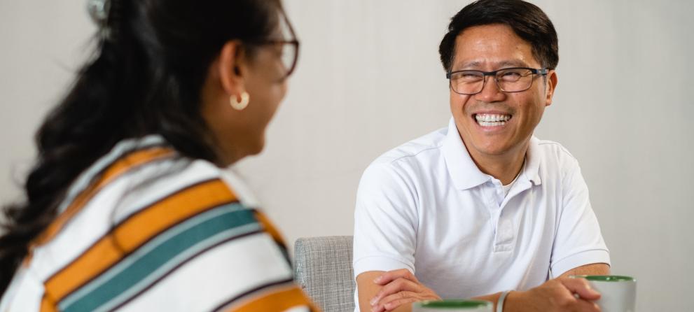 Young people laughing and looking at a notebook